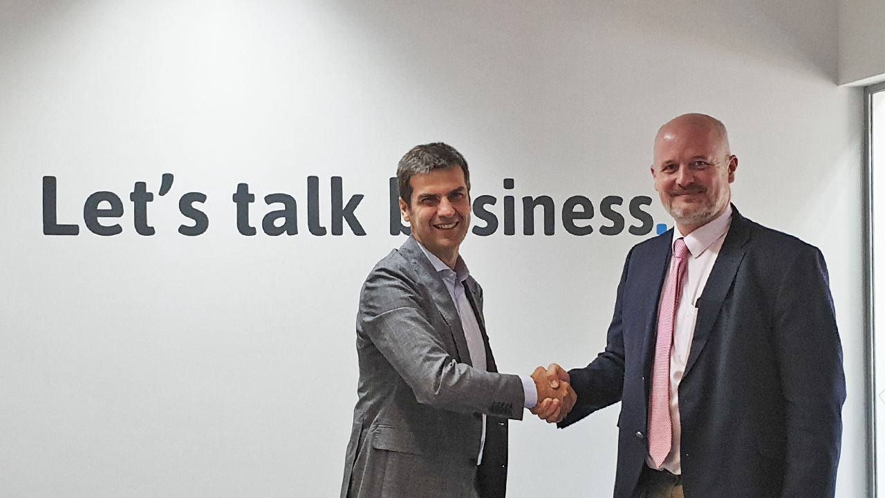 Image of two peoploe shaking hands. On the background the sentence: "Let's talk about business"